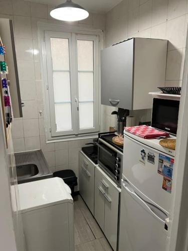 Il comprend une petite cuisine équipée d'une cuisinière et d'un réfrigérateur. dans l'établissement Appartement T2 cosy et lumineux au cœur de Paris12, à Paris