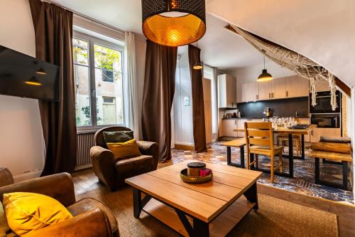 un salon avec une table et une cuisine dans l'établissement Maison cocon, à Dijon
