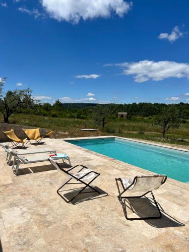 two chairs and a swimming pool on a patio at Villa Loan in Mollans-sur-Ouvèze