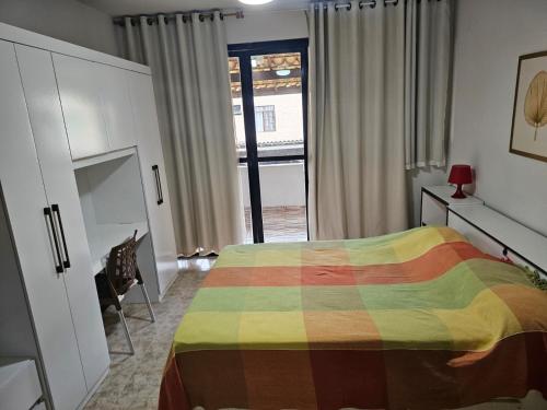 a bedroom with a bed with a colorful blanket at Brisa do Mar Village in Salvador