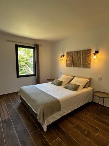 une chambre avec un grand lit et une fenêtre dans l'établissement Villa Loan, à Mollans-sur-Ouvèze