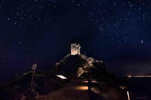 a building on top of a mountain at night at Dentro Scopello - Casa Vacanze in Scopello