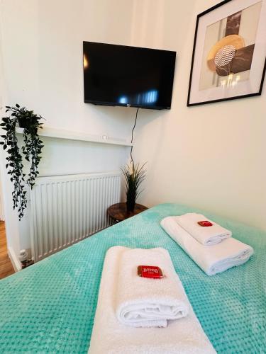 a room with a bed with two towels on it at Elegant Private Room opposite Queen Elizabeth Hospital - Harborne Birmingham R2 in Birmingham