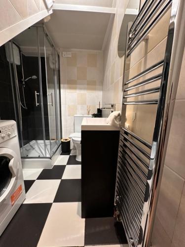 a bathroom with a black and white checkered floor at Elegant Private Room opposite Queen Elizabeth Hospital - Harborne Birmingham R2 in Birmingham