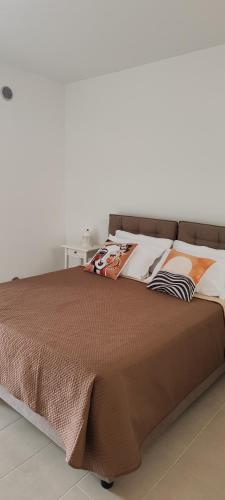 a bed with a brown bedspread on top of it at Little Rose in Catania