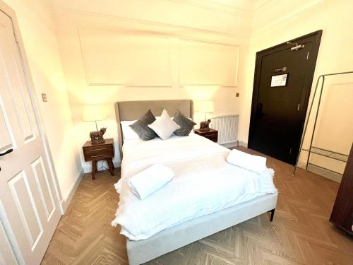 a bedroom with a bed with white sheets and pillows at 'Mac' in ApartNest Auchterarder in Auchterarder