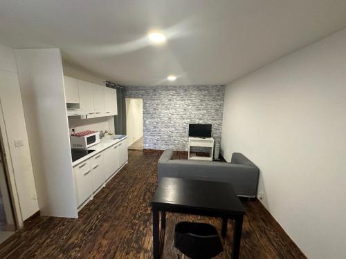 une cuisine avec des armoires blanches et une table dans une pièce dans l'établissement Centre, à Morlaix