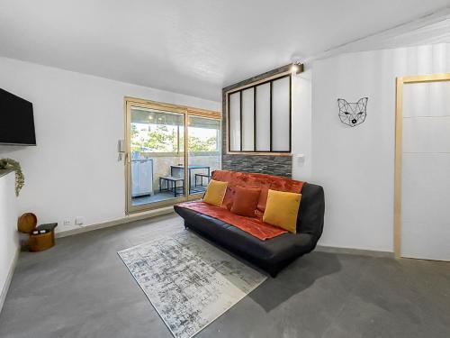 un salon avec un canapé et une fenêtre dans l'établissement Retraite Romantique à Sainte-Maxime, à Sainte-Maxime