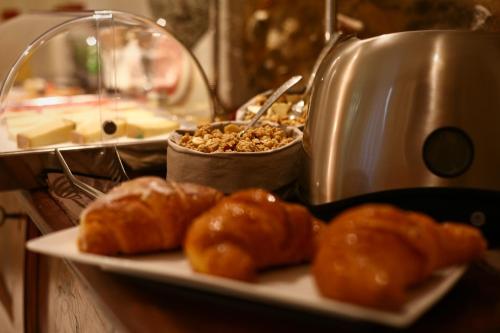 a plate of food with croissants on a table at Art Boutique Hotel Acchiappasogni in Barga