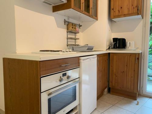 La cuisine est équipée de placards en bois et d'un four blanc. dans l'établissement Studio cosy proche télécabine et thermes, balcon ombragé, wifi inclus, animaux acceptés - FR-1-512-125, à Brides-les-Bains