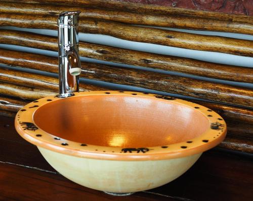 a bathroom with a sink with a foss at Muweti Bush Lodge in Grietjie Nature Reserve