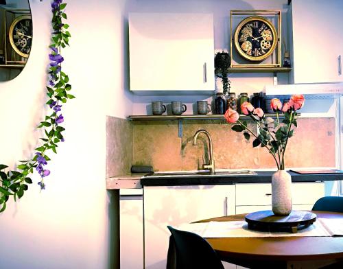 a kitchen with a table with a vase of flowers on it at Le King & Suites étoilées in Gréoux-les-Bains