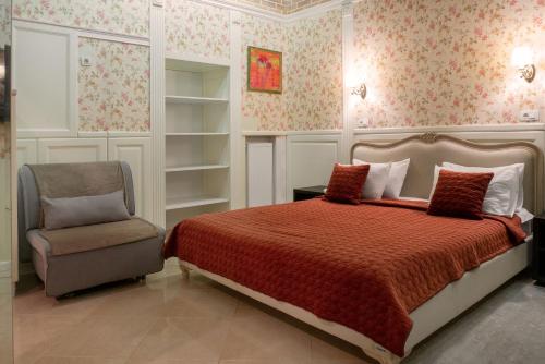 a bedroom with a bed and a chair at Shato Luxe in Odesa