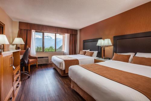 a hotel room with two beds and a window at Coast Hillcrest Hotel in Revelstoke