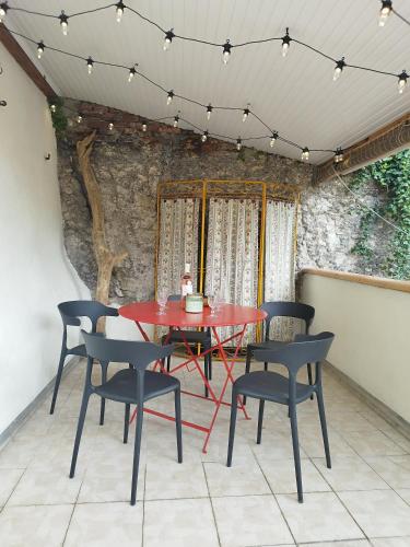 - une table et des chaises rouges sur la terrasse dans l'établissement Par Saint Georges !, à Cahors