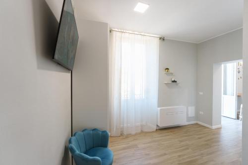 a living room with a blue chair and a window at Dimora del Corso Luxury house in Pescara