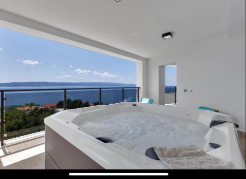 a white bath tub in a room with a large window at Ivana&Luka-Put luke 1, Brela in Brela