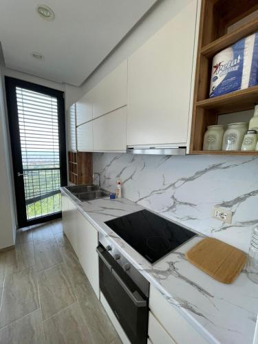 a kitchen with white cabinets and a counter top at Apartment with view in Tirana in Shkozë