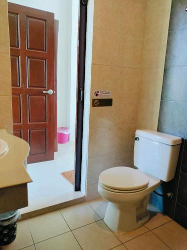 a bathroom with a toilet and a shower with a door at Jigsaw Cafe & Resort in Ban Na We