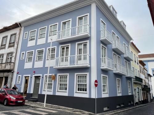a blue building with a car parked in front of it at Azimute 3 - T2 Moderno Centro Histórico Angra in Angra do Heroísmo