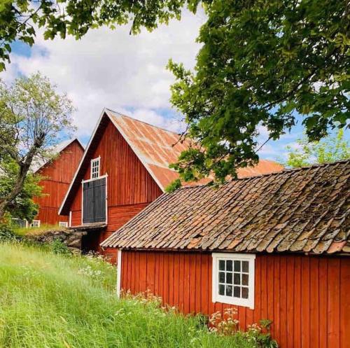 a red barn sitting on top of a hill at Walters Country Cottage i Jönköping in Jönköping