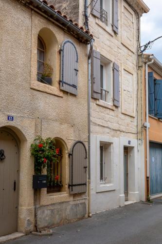 an old building with flowers in a window at Chez Sylvie - Étonnante maison climatisée dans les remparts in Aigues-Mortes