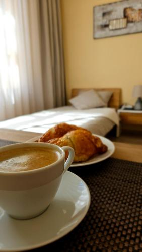 a table with a cup of coffee and a plate of food at Center Apartments Tukums in Tukums