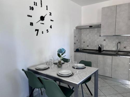 a dining room table with chairs and a clock on the wall at La Noce Holiday House in Massa Lubrense