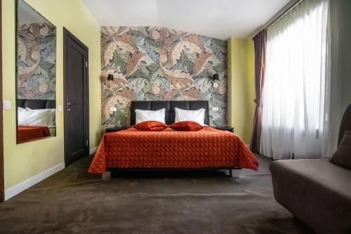 a bedroom with a bed with a red comforter at Shato Luxe in Odesa