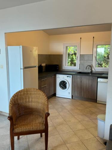 une cuisine avec un réfrigérateur et une machine à laver dans l'établissement villa arbutu, à Olmeto