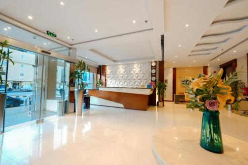 a lobby with a vase of flowers on a table at Celine Home Serviced Apartment Al Malqa in Riyadh