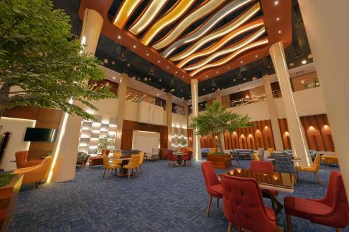 a lobby with chairs and tables and chairs and a lobby at Celine Home Serviced Apartment Al Malqa in Riyadh