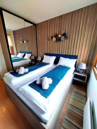 une chambre avec un grand lit avec des draps bleus et blancs dans l'établissement Apartman Bojic, à Palisat