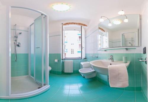 La salle de bains est pourvue d'un lavabo, de toilettes et d'une douche. dans l'établissement La casa del pescatore - a due passi dalle spiagge, à Santa Margherita Ligure