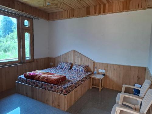 a bedroom with a bed and a chair in it at Paras Homestay in Shoja