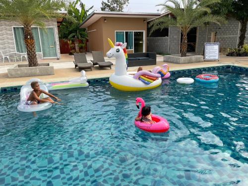 a group of children riding on inflatables in a swimming pool at vasita homestay satun in Ban Thung Nui