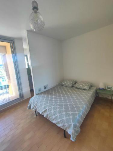 une chambre avec un lit dans une pièce avec une fenêtre dans l'établissement GRUISSAN, Studio Cabine, Au Calme VUE DÉGAGÉE SUR MARINA, à Gruissan