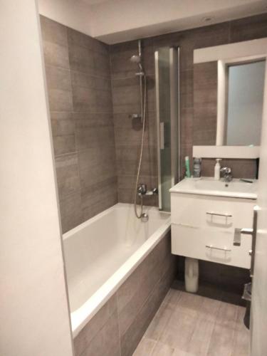 une salle de bain avec une baignoire et un lavabo dans l'établissement 10mm a pied des plages, appartement olympe climatisé, à Antibes