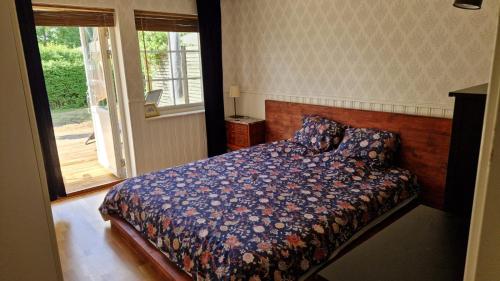a bedroom with a bed and a sliding glass door at Blå rummet - Rum i familjärt boende - Sängkläder & handdukar ingår in Färjestaden