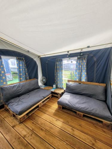 a room with two beds in a tent at Surf Przyczepa Jastarnia in Jastarnia