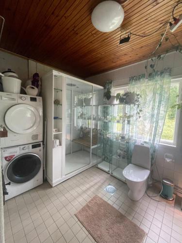 a bathroom with a washing machine and a toilet at Villa Kurenniemi in Taipalsaari