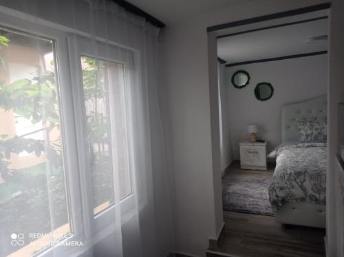 a bedroom with a bed and a large window at Casa ROOL in Turda