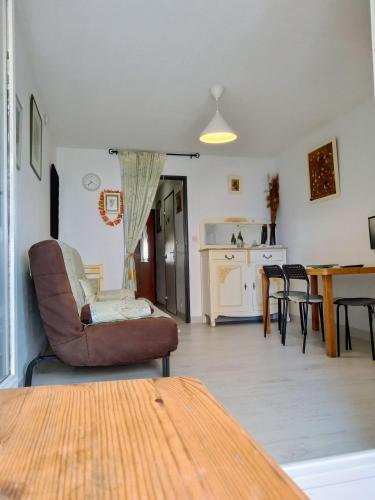 un salon avec une table et des chaises et une cuisine dans l'établissement MER indigo & FLAMANTS Roses vue mer 5mn plage et parc des expositions Arena aeroport, à Mauguio