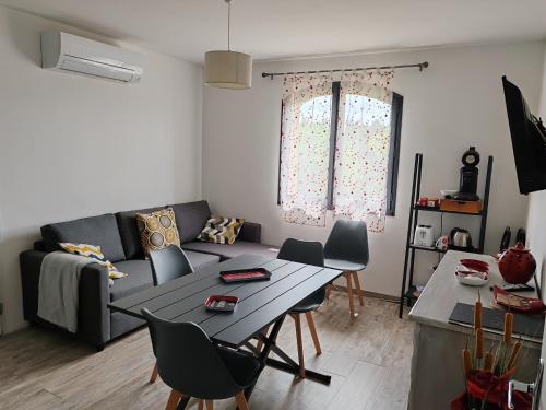 un salon avec un canapé et une table dans l'établissement LES CHÂTAIGNIERS APPARTEMENT MEUBLE, à Saint-Sèbastien