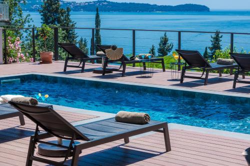 a patio with chairs and a swimming pool with the water at Villa Hortensia-With Private Pool and Beaches Front in Mlini