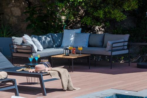 a patio with a blue couch and a table and chairs at Villa Hortensia-With Private Pool and Beaches Front in Mlini