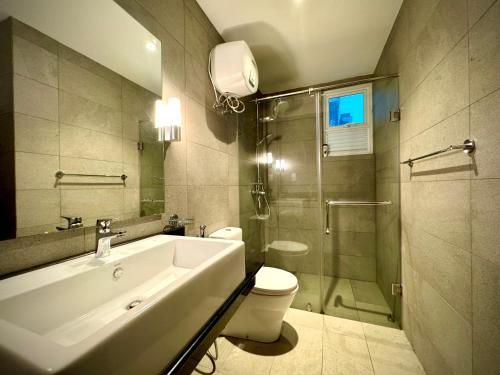 a bathroom with a sink and a toilet and a shower at Pearl Of Ocean Front in Trincomalee