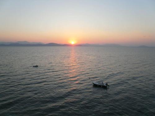 a boat in the middle of the ocean at sunset at Seaview Studio Helen No 6 in Xiropigado