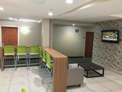 a bar in a waiting room with green stools at Corona Hotel New York - LaGuardia Airport in Queens