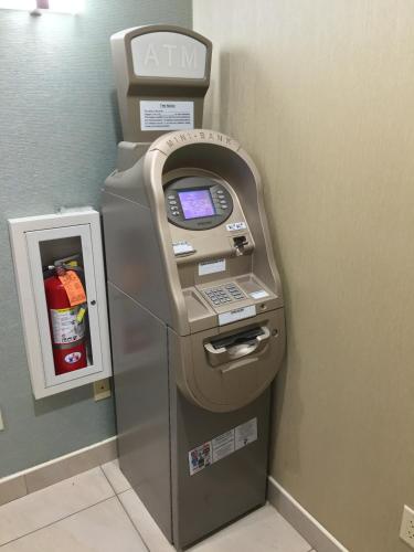 an atm machine in a room with a wall at Corona Hotel New York - LaGuardia Airport in Queens